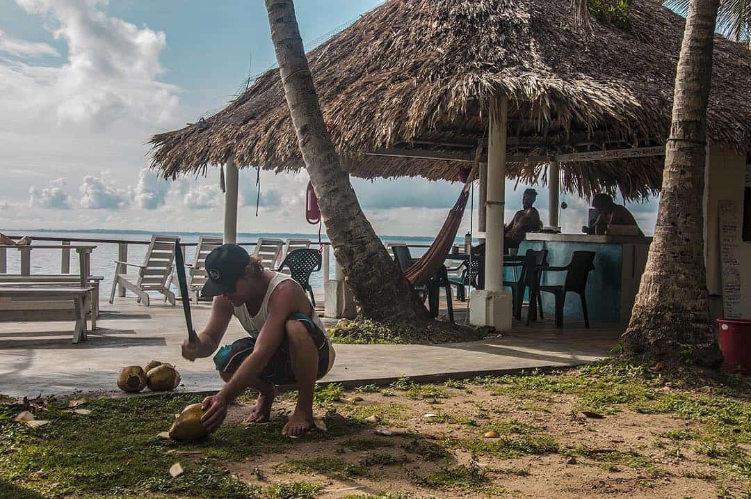 A man opening a coconut with a machete